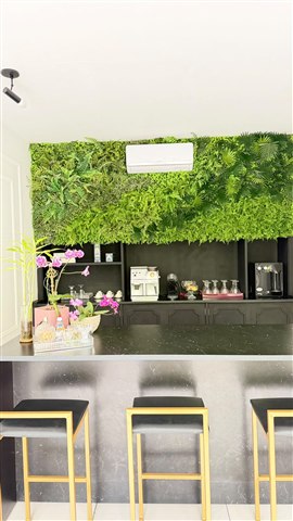 Área do café com jardim vertical, balcão e banquetas